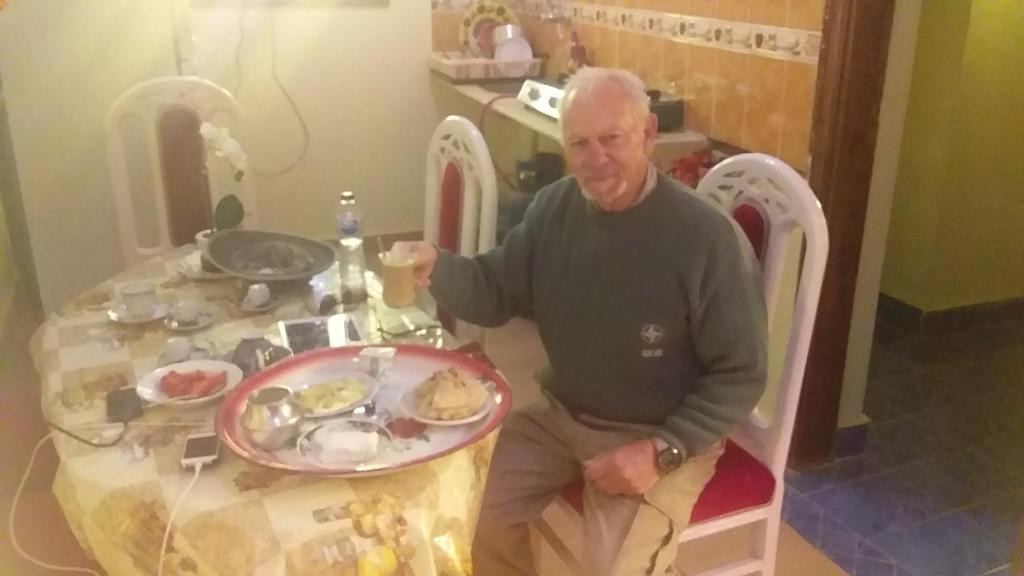 a man sitting at a table with a plate of food at Roma House in Aswan