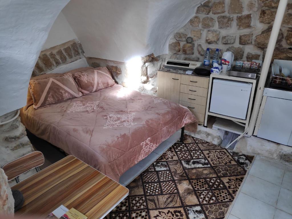 a small bedroom with a bed and a kitchen at Dar Jacaman - In the heart of Bethlehem old city in Bethlehem