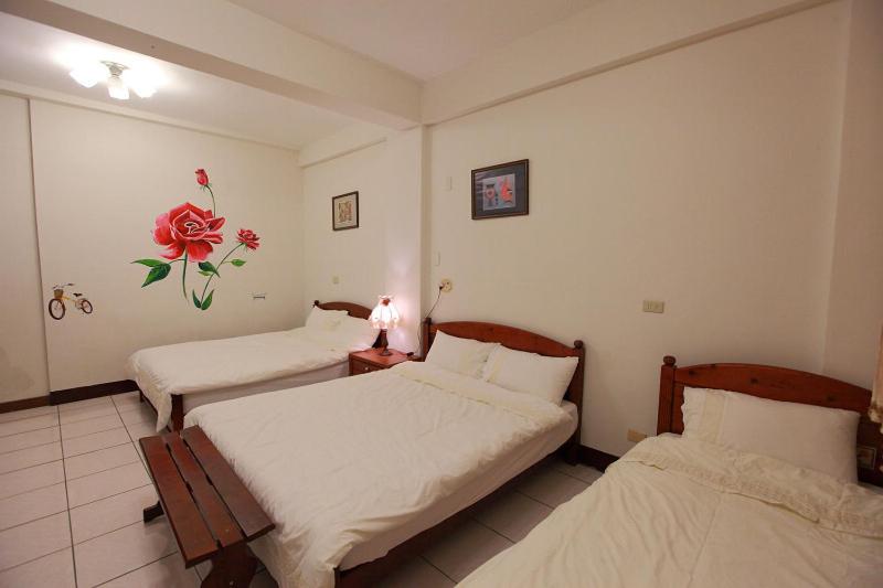 a bedroom with two beds and a flower on the wall at Lily House in Ji&#39;an