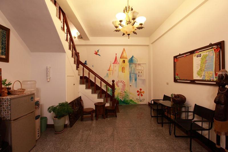 a room with a staircase with chairs and a screen at Lily House in Ji&#39;an