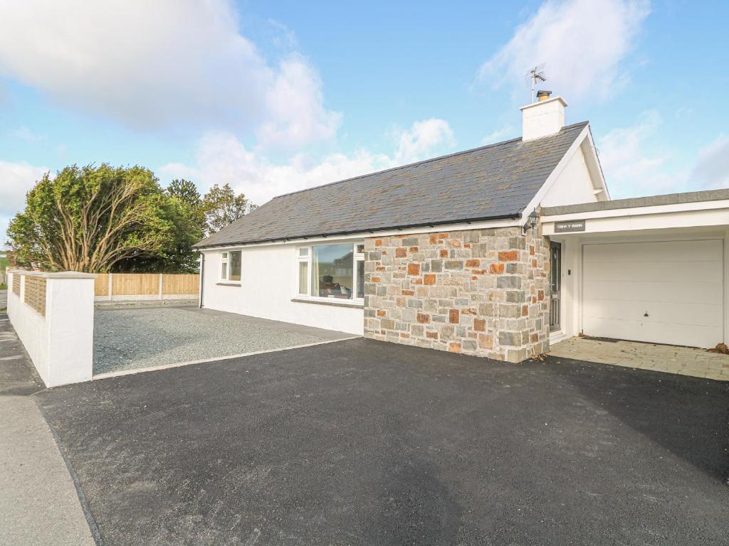 a detached garage with a driveway at Trem Y Garn in Pwllheli