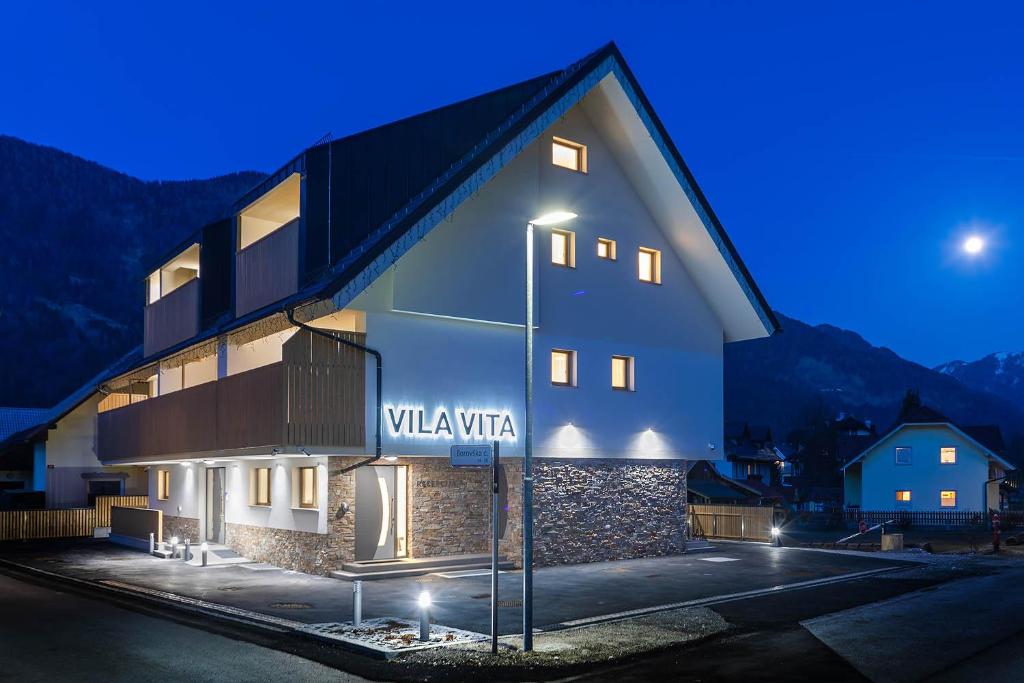 un bâtiment avec un panneau indiquant la villa vienna la nuit dans l'établissement Vila Vita Apartments, à Kranjska Gora
