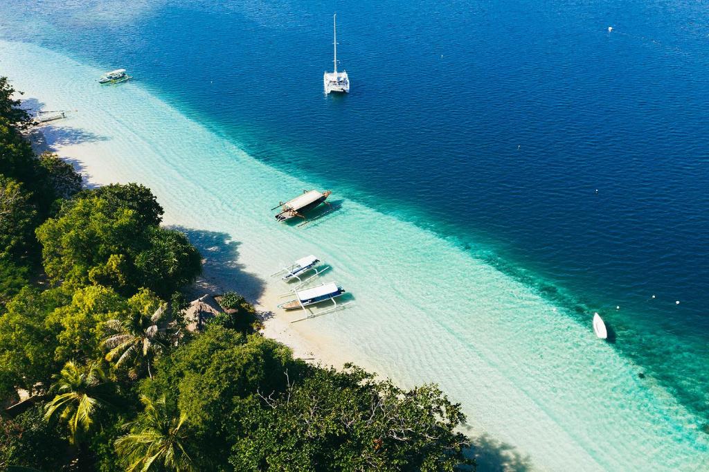 an aerial view of a beach with boats in the water at Gili Asahan Eco Lodge & Restaurant in Gili Asahan