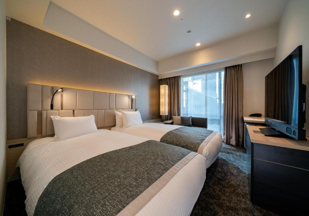 Llit o llits en una habitació de Daiwa Roynet Hotel Tokyo Kyobashi PREMIER