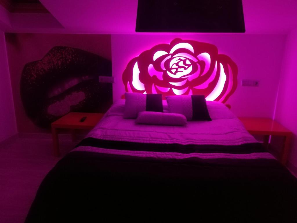 a purple bedroom with a bed with a flower on it at Islabeach in Isla