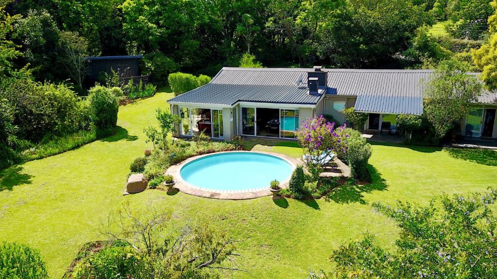 una vista aérea de una casa con una piscina en un patio en Cathkin Cottage Bed & Breakfast, en Champagne Valley