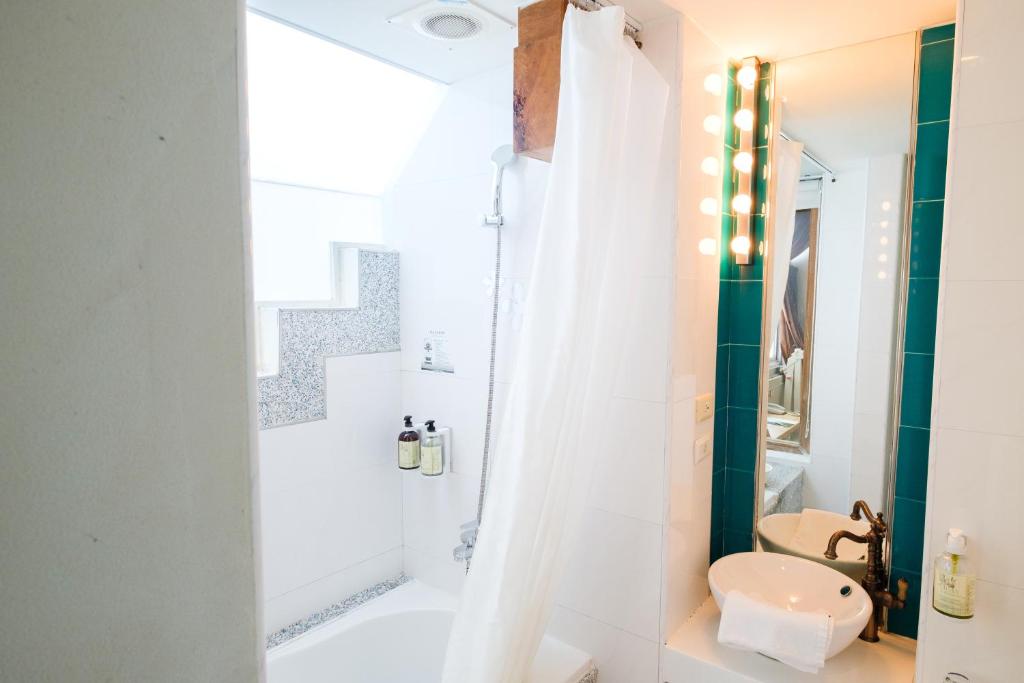 a bathroom with a white tub and a shower at SSS Life Hotel in Tainan