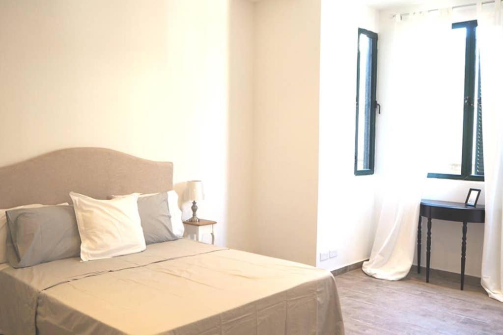 Un dormitorio con una cama con sábanas blancas y una ventana. en STUDIO in the CITY, en La Valeta