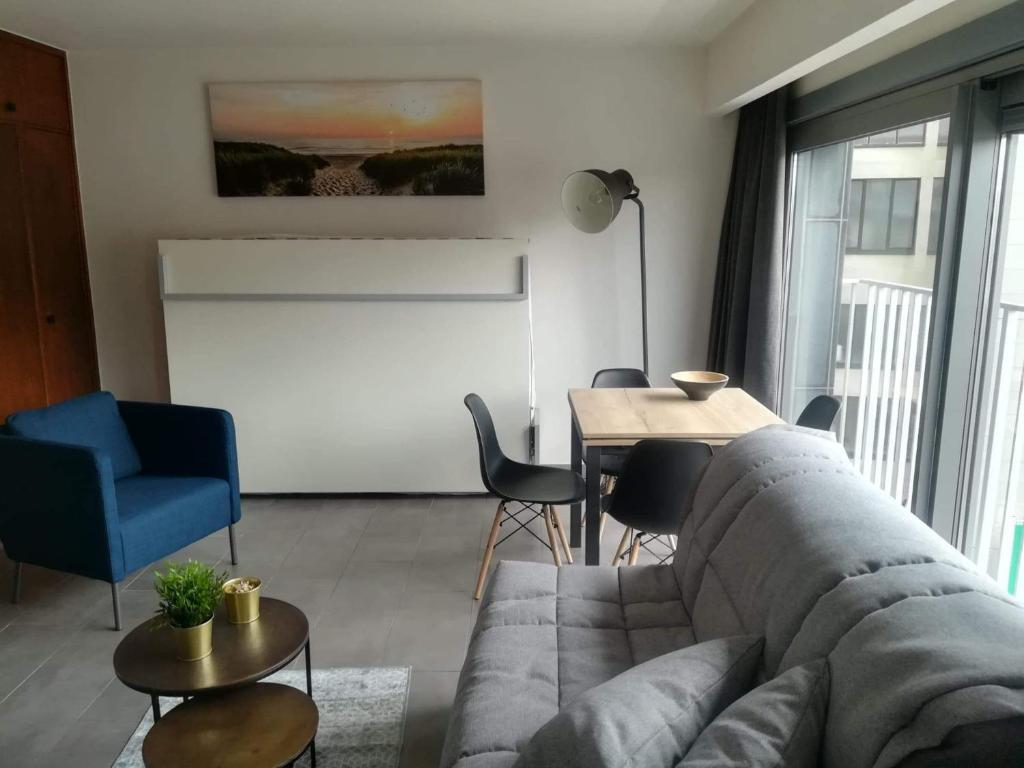 ein Wohnzimmer mit einem Sofa und einem Tisch in der Unterkunft BC Studios in Blankenberge