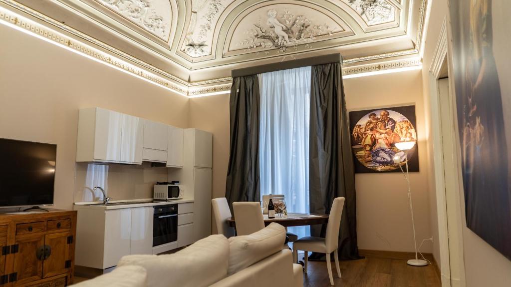 a living room with a couch and a table with chairs at Duca di Sarro le Suites in Catania