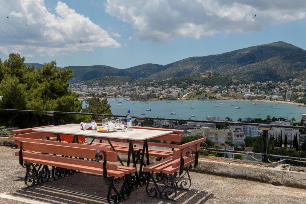 d'une table et de bancs sur un balcon avec vue sur le lac. dans l'établissement Niki seaview apartment, à Pórto Ráfti
