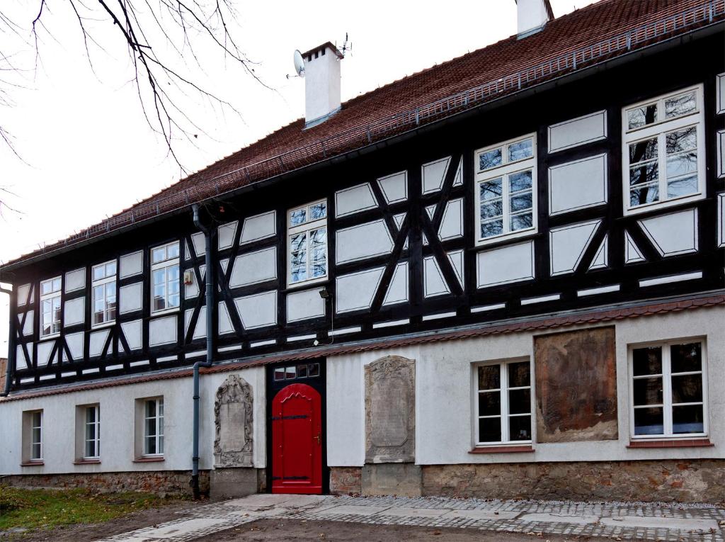 シュフィドニツァにあるバロコヴィ ザコンテクの赤い扉のある白黒の古い建物