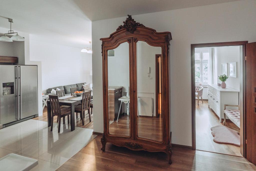 a living room with a large mirror and a dining room at Apartament Rynek - Zielona Kamienica in Duszniki Zdrój