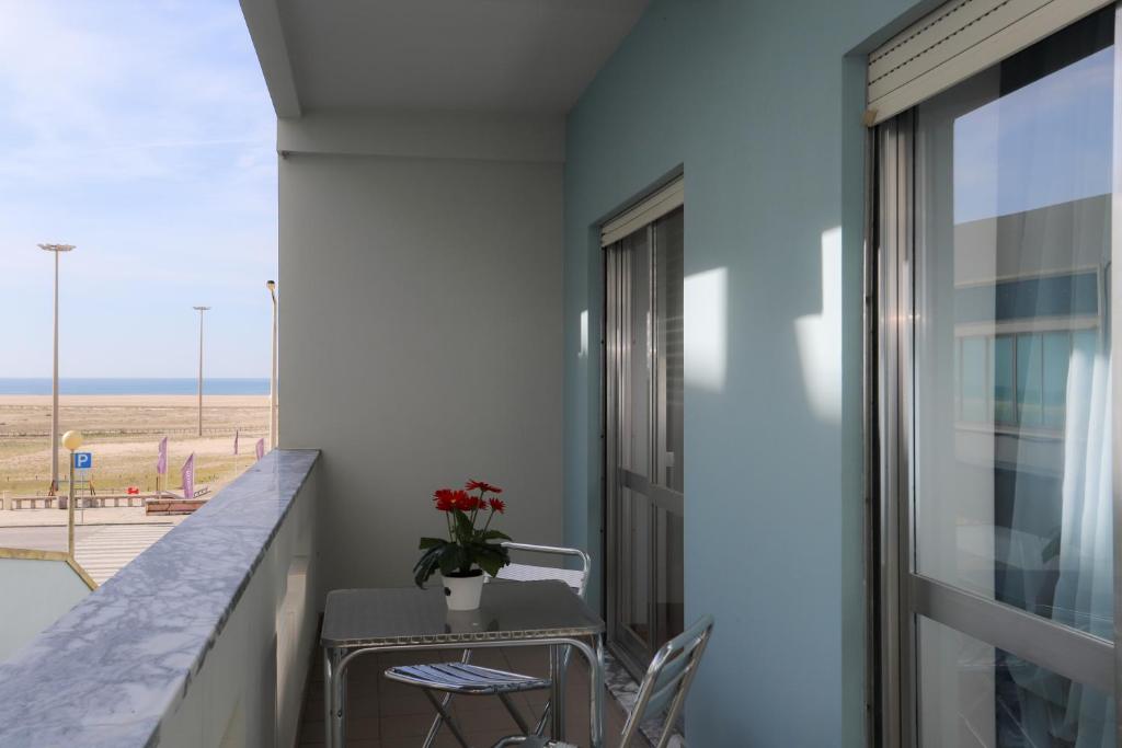 een balkon met een tafel en stoelen en uitzicht op het strand bij Figueira Coast View Apartment in Figueira da Foz