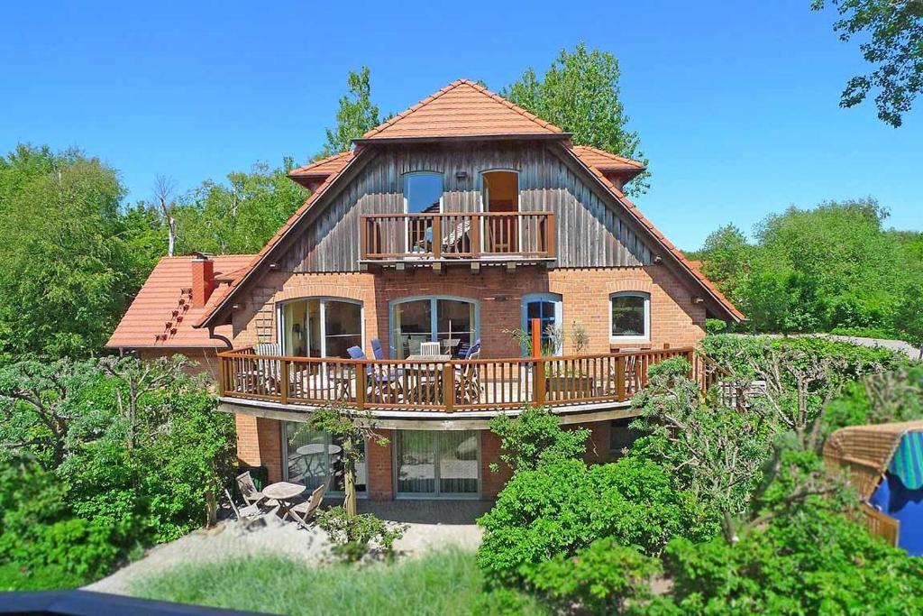 ein großes Haus mit einem Balkon und einer Terrasse in der Unterkunft Dünenhof DÜNENHOF Whg. D-07 in Wustrow