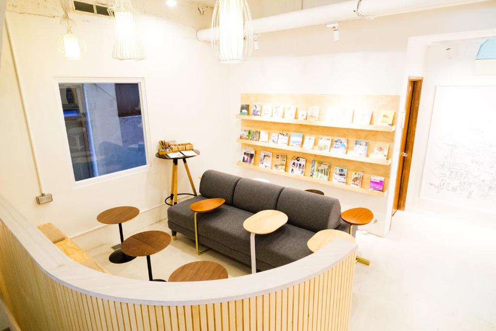 a waiting room with a couch and stools at SSS Life Hotel in Tainan