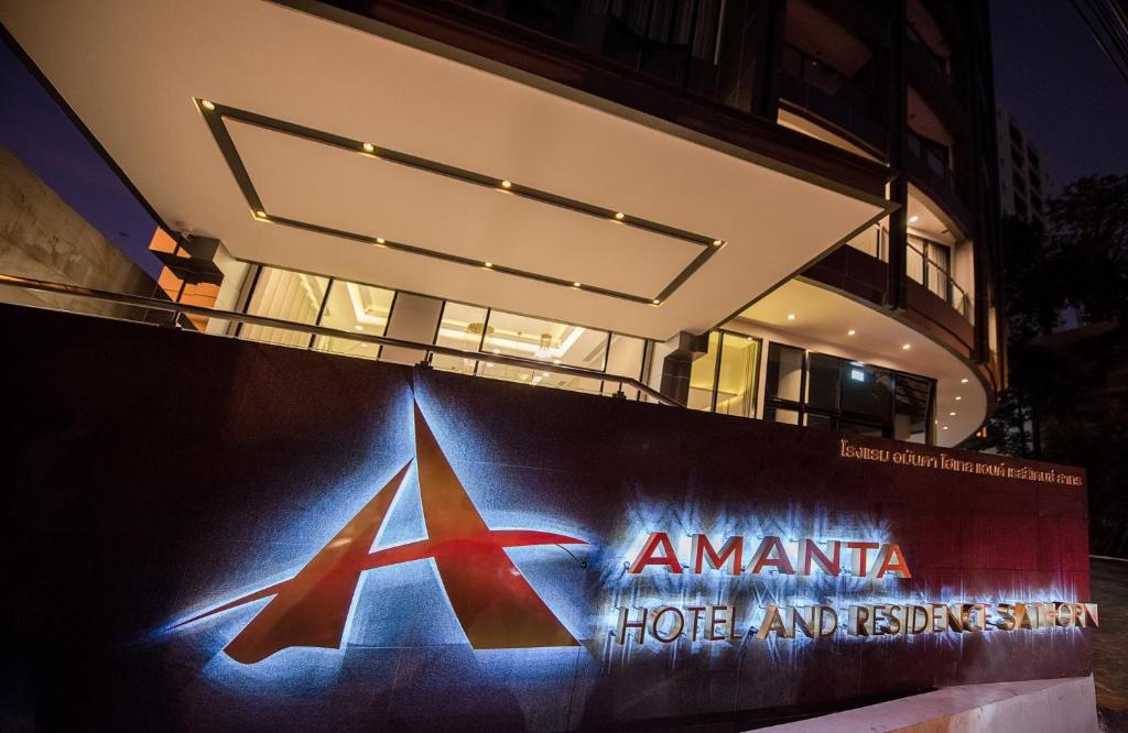 una señal frente a un edificio por la noche en Amanta Hotel & Residence Sathorn en Bangkok