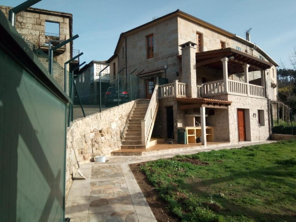 uma casa velha com uma escada em frente em Vivienda Turísitica A Petada de San Clodio em Gomariz