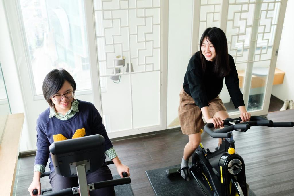 two women playing with an exercise bike in a room at SSS Life Hotel in Tainan