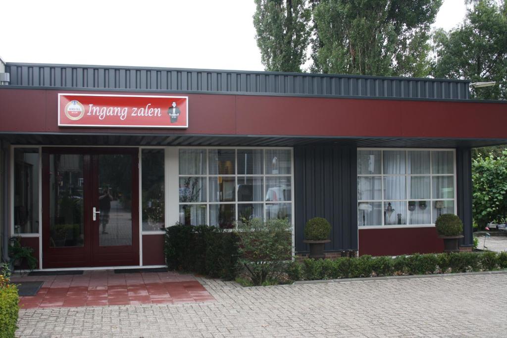 un bâtiment avec un panneau rouge devant lui dans l'établissement Hotel Café Restaurant Snackbar Beerzerveld, à Beerzerveld