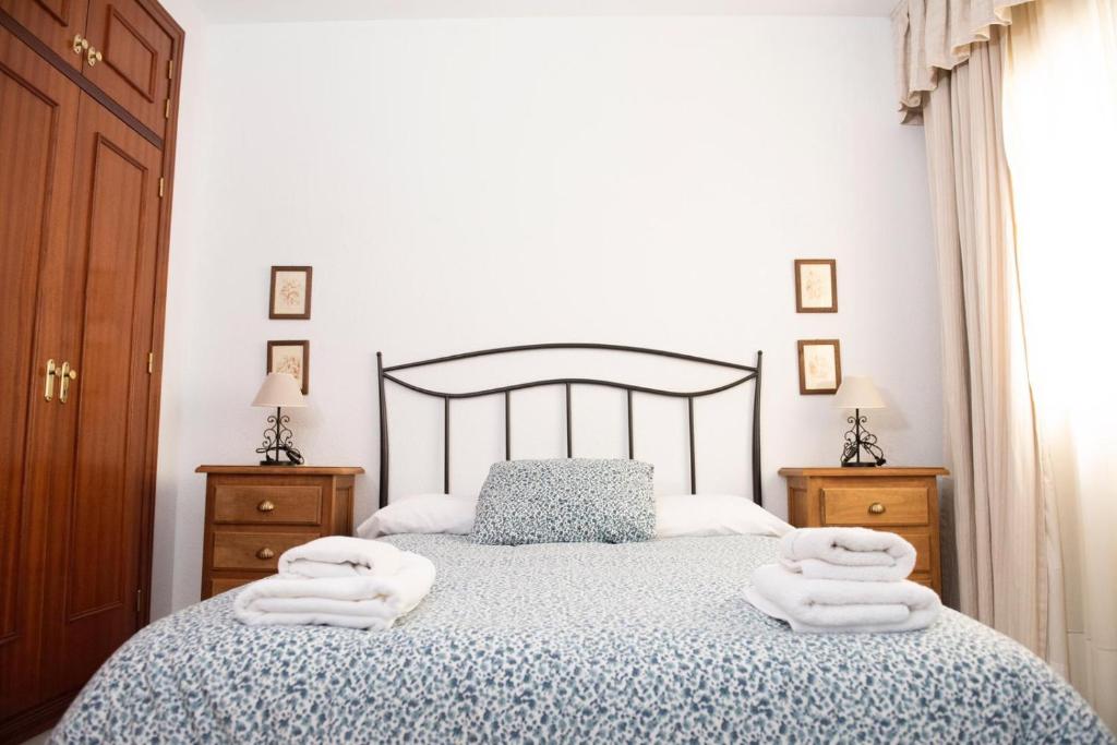 una camera da letto con un letto e asciugamani di Las Mellizas a Cenes de la Vega
