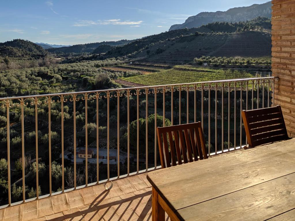 einen Balkon mit 2 Stühlen und Blick auf einen Weinberg in der Unterkunft L'Acadèmia de La Vilella Baixa 1 in La Vilella Baixa