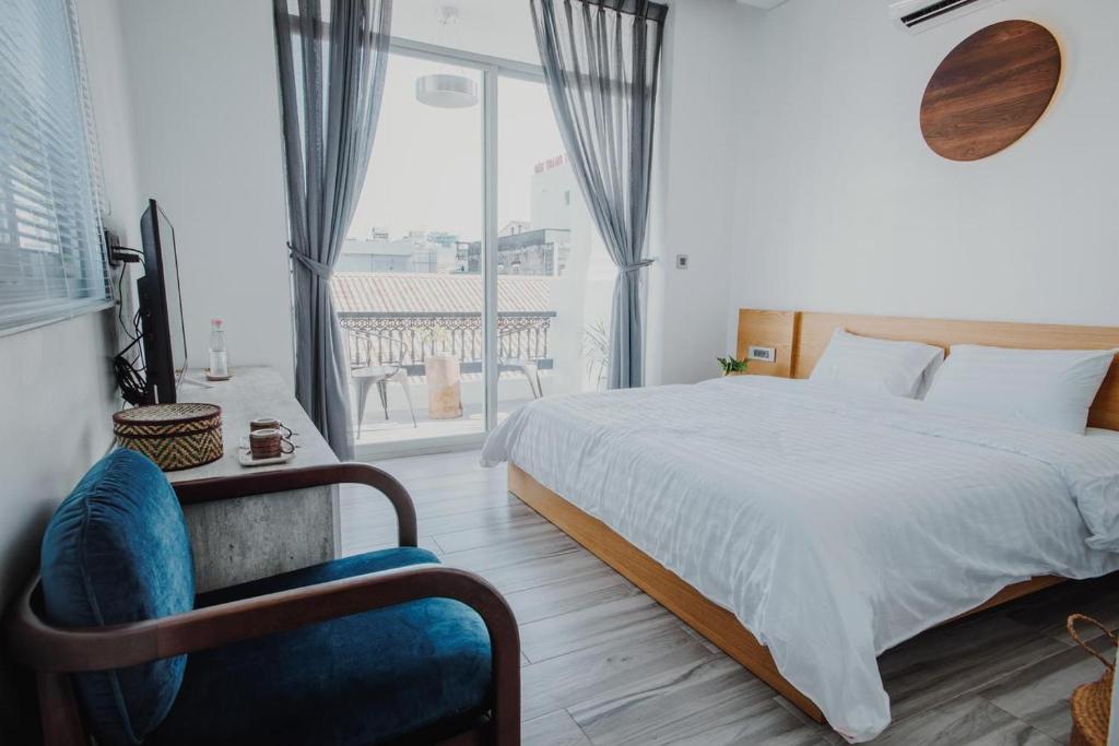 ein Schlafzimmer mit einem Bett, einem Stuhl und einem Fenster in der Unterkunft Vien Hotel in Cần Thơ
