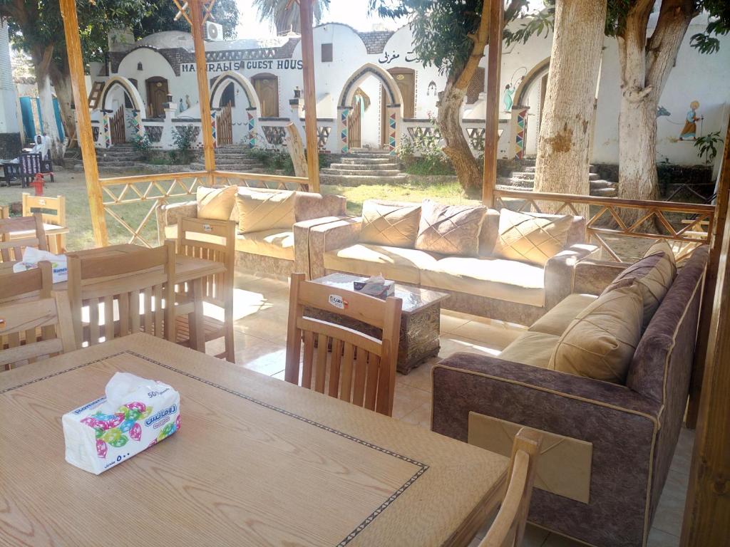 un soggiorno con tavoli, divani e alberi di Maghrabi's Guest house a Aswan