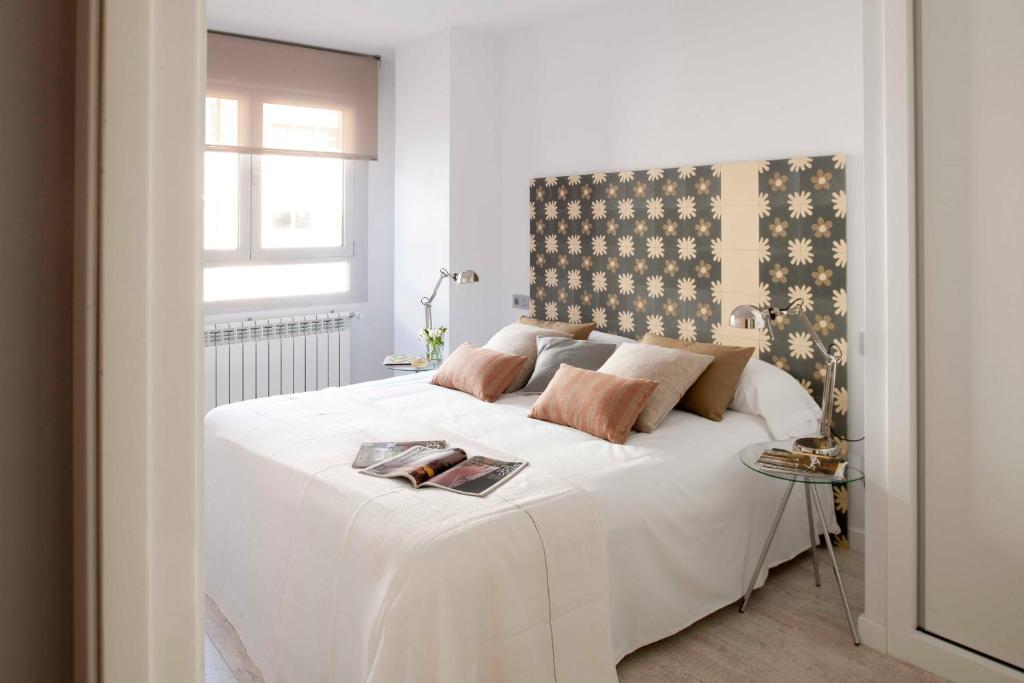 a bedroom with a large white bed with a window at Eric Vökel Boutique Apartments - Atocha Suites in Madrid