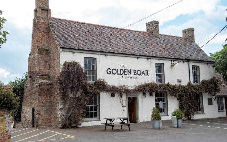 un edificio con un cartel que lee el bar goblin en The Golden Boar, en Newmarket