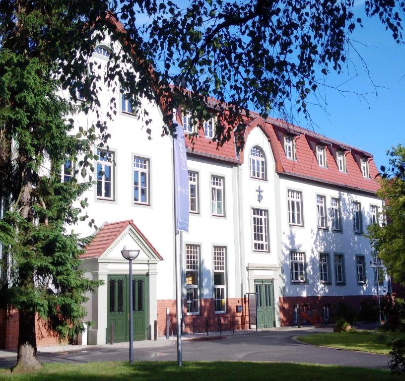 een groot wit gebouw met een rood dak bij Bildungs- und Begegnungsstätte Brüderhaus in Rothenburg ob der Tauber