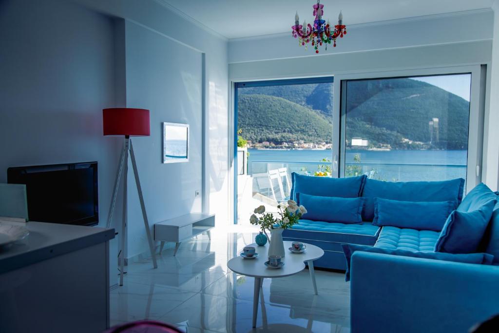 a living room with a blue couch and a large window at Seafront Luxury residence with amazing view in Vasiliki