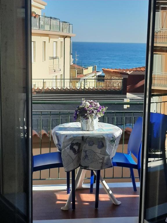 una mesa y sillas en un balcón con vistas al océano en Jak's Home Laigueglia, en Laigueglia