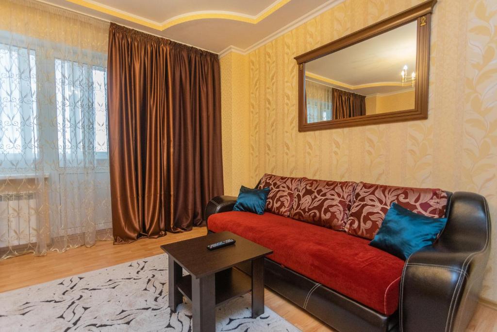a living room with a couch and a mirror at FiveStars Kuban in Krasnodar