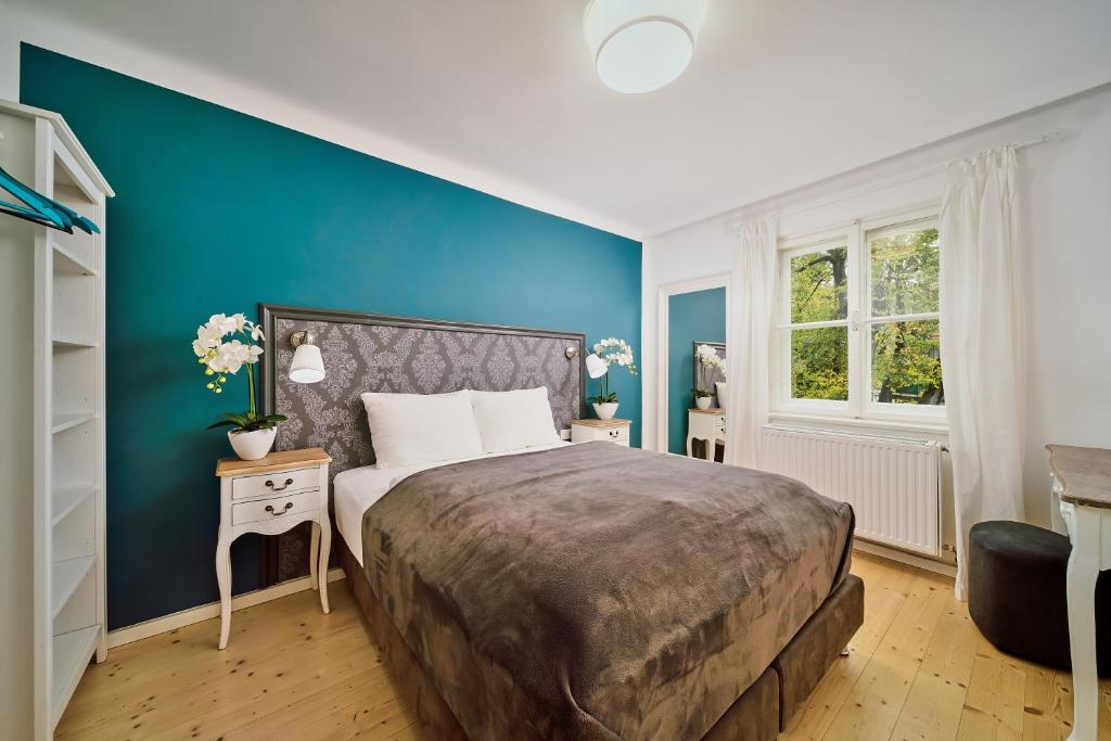 a bedroom with a large bed and a blue wall at Salzburg Residence by Welcome to Salzburg in Salzburg