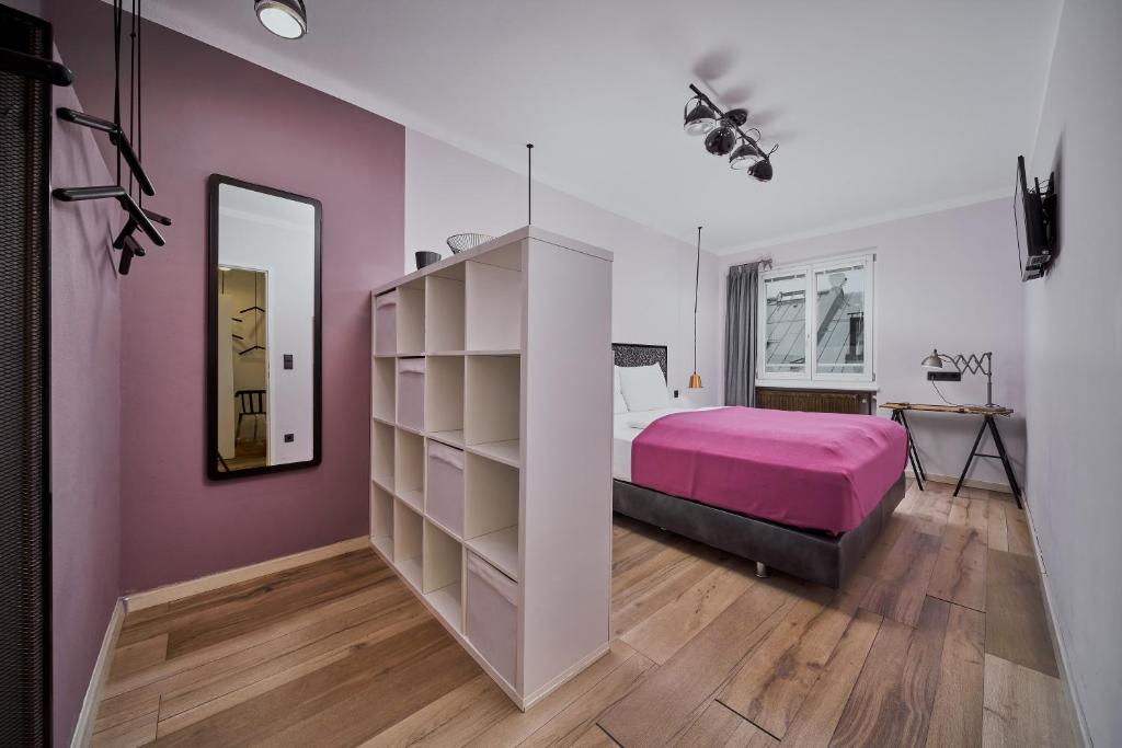 een slaapkamer met een roze bed en een spiegel bij Salzburg Topside Apartment in Salzburg