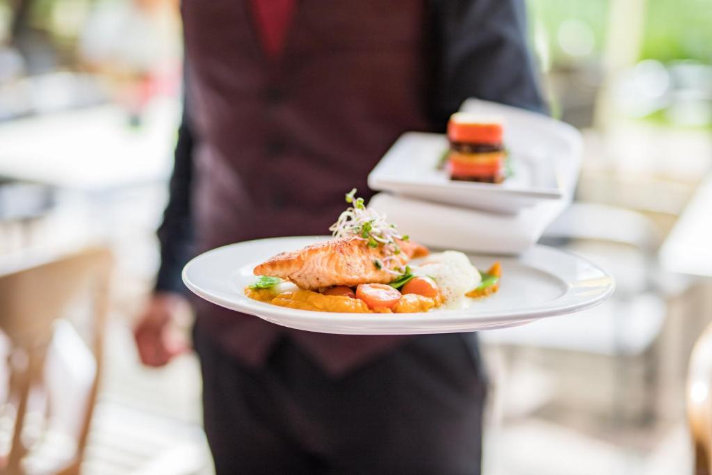 a person is holding a plate of food at Hotel am Schloß Apolda in Apolda