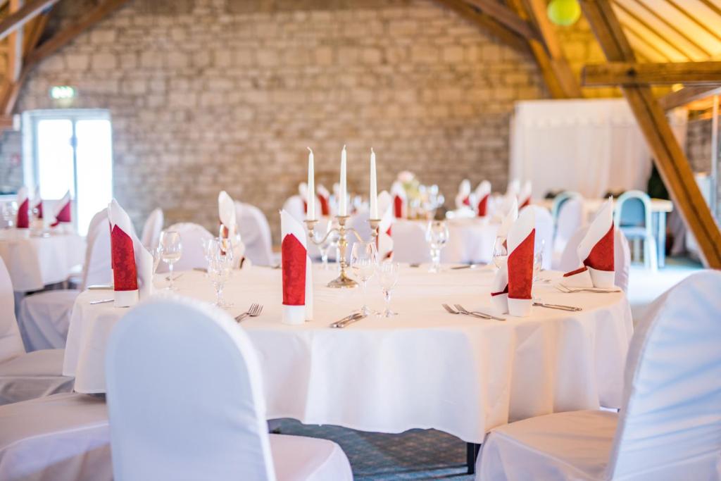 a group of tables with red napkins on them at Hotel am Schloß Apolda in Apolda