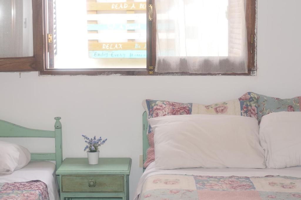 a bedroom with a bed and a table and two windows at HOSTAL TILIAN in Salta
