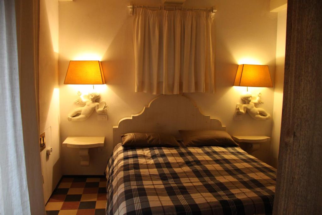 1 dormitorio pequeño con 1 cama y 2 lámparas en CASA CORSICA con parcheggio gratuito, en Orvieto