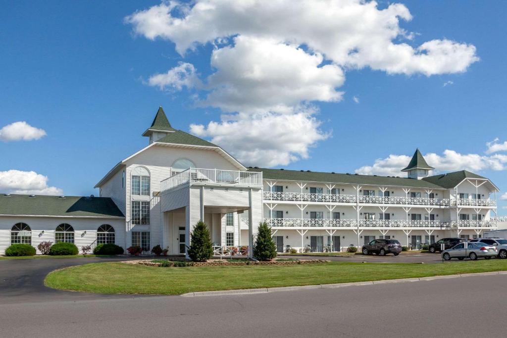 duży biały budynek z samochodami zaparkowanymi na parkingu w obiekcie Clarion Hotel & Suites w mieście Wisconsin Dells