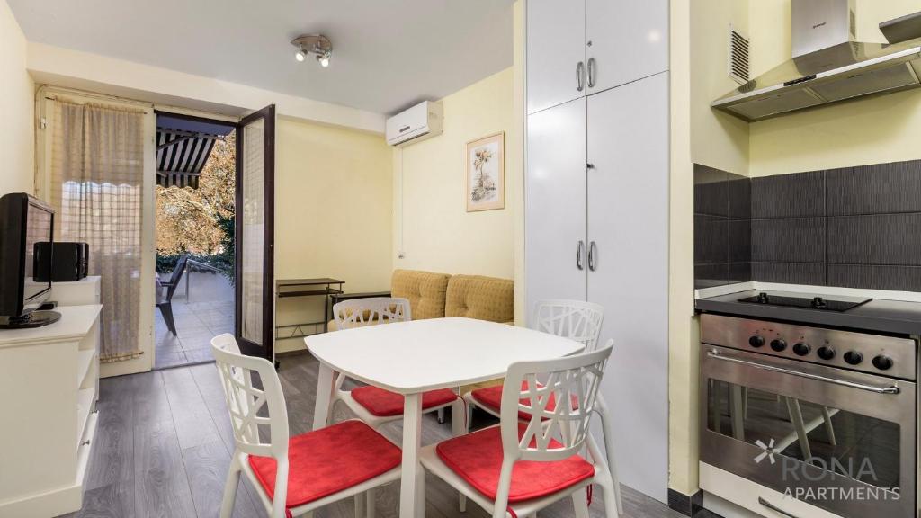 a kitchen and dining room with a table and chairs at Rona Apartment Porat in Poreč