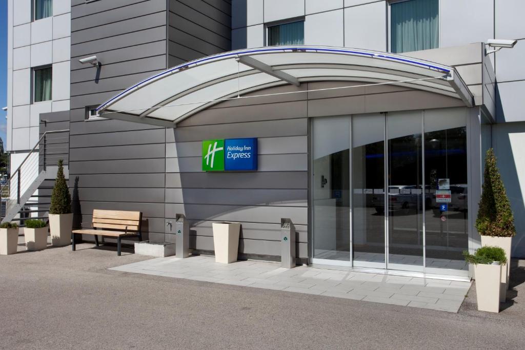 una entrada a un edificio con un cartel en Holiday Inn Express Geneva Airport, an IHG Hotel en Ginebra