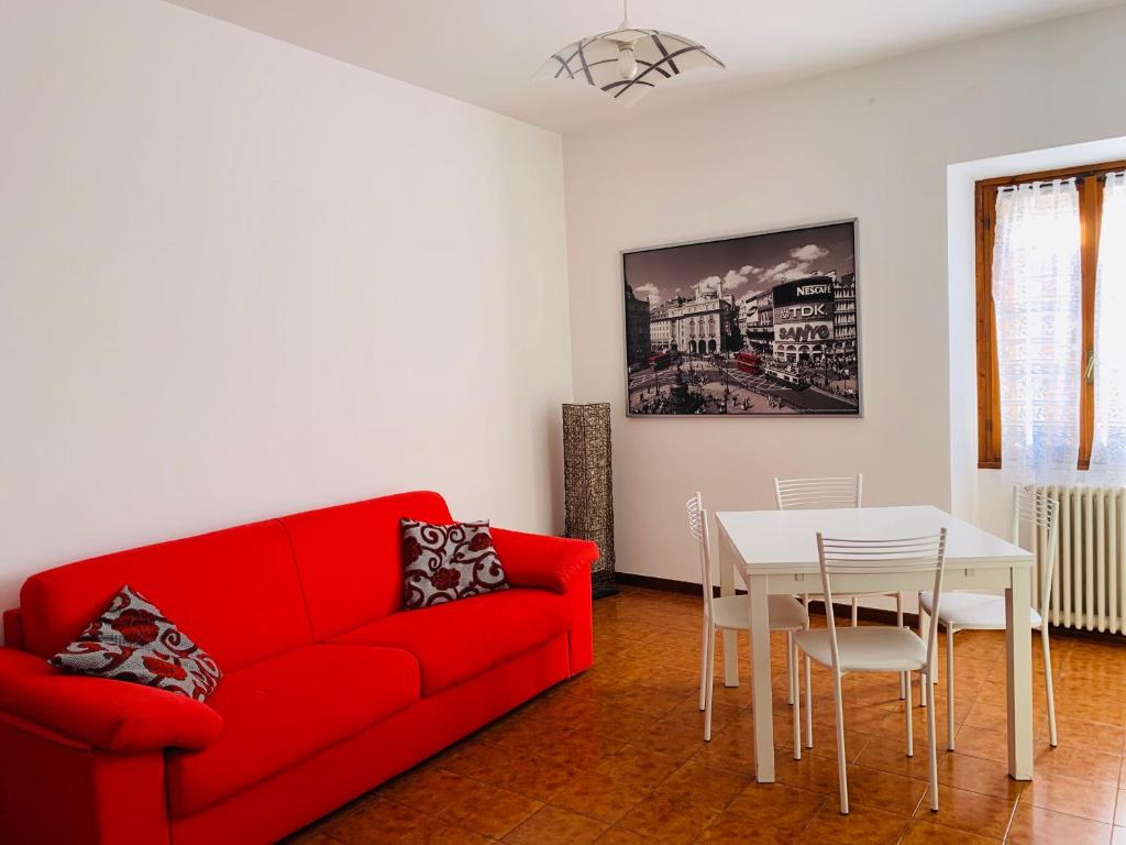sala de estar con sofá rojo y mesa en Appartamento Rosso, en Lazise