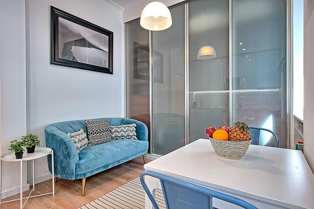 uma sala de estar com um sofá azul e uma mesa em Graça 4 em Lisboa