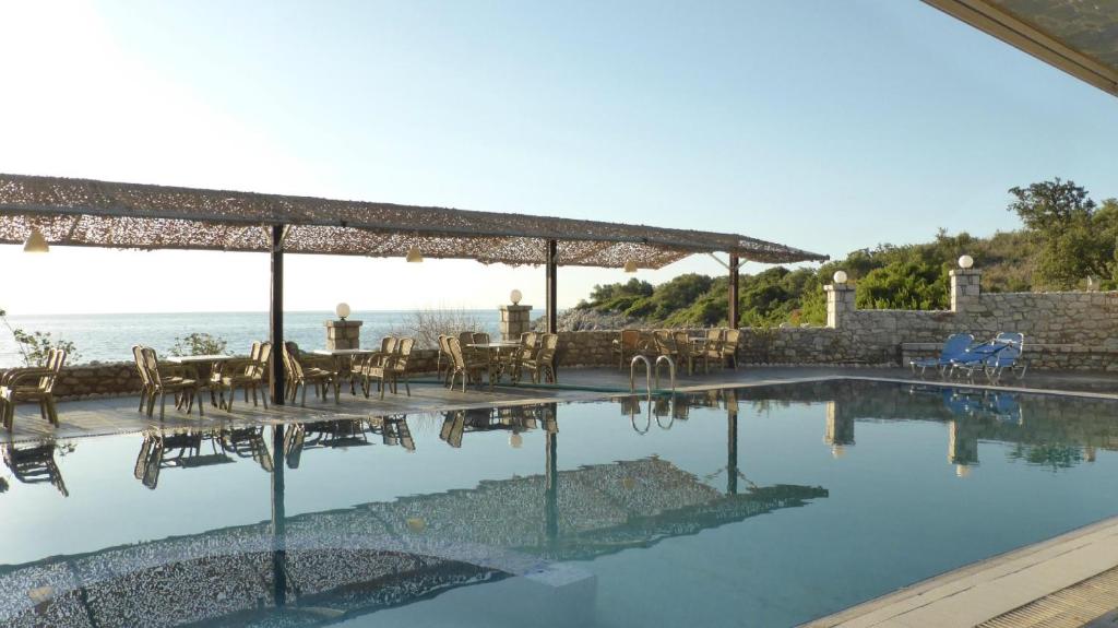 Éxo Nímfion的住宿－Lalloudes Seaside Accommodation，毗邻大海的带桌椅的游泳池