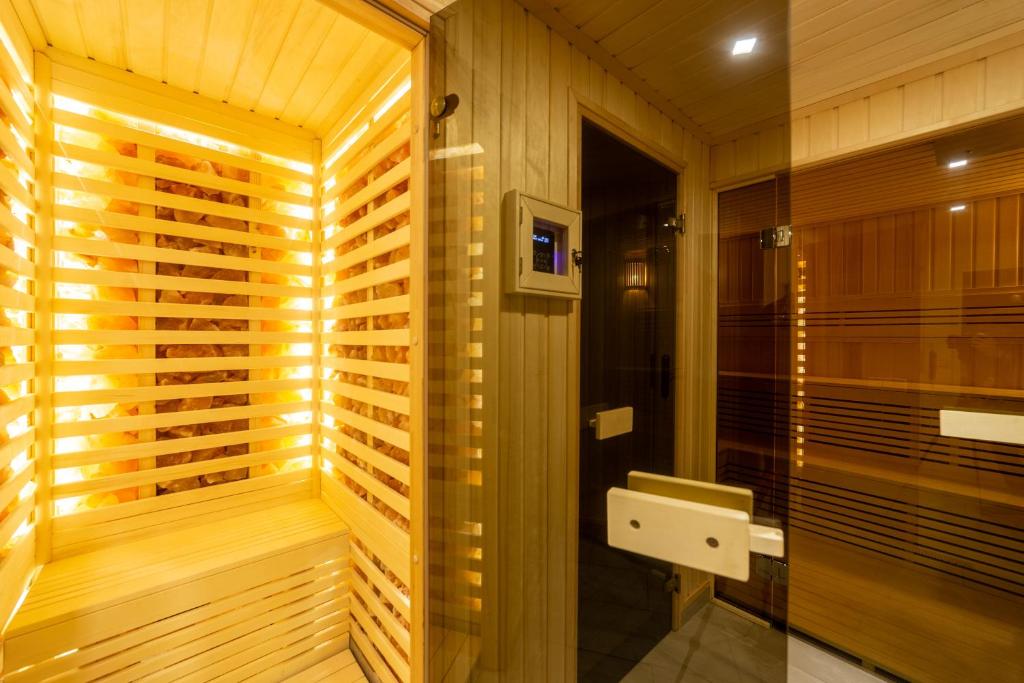 sauna con paredes revestidas de madera y cabina de ducha en Márvány Panzió, en Hajdúszoboszló