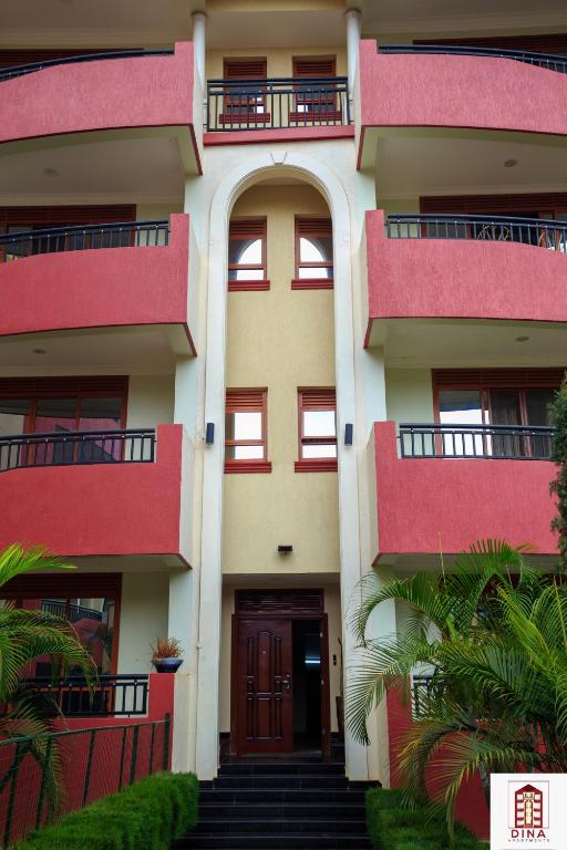 a building with red balconies and a door at Dina Apartments in Kampala