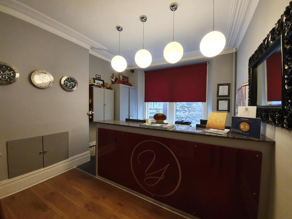 a kitchen with a counter with a refrigerator and clocks at The York Hotel in Weston-super-Mare