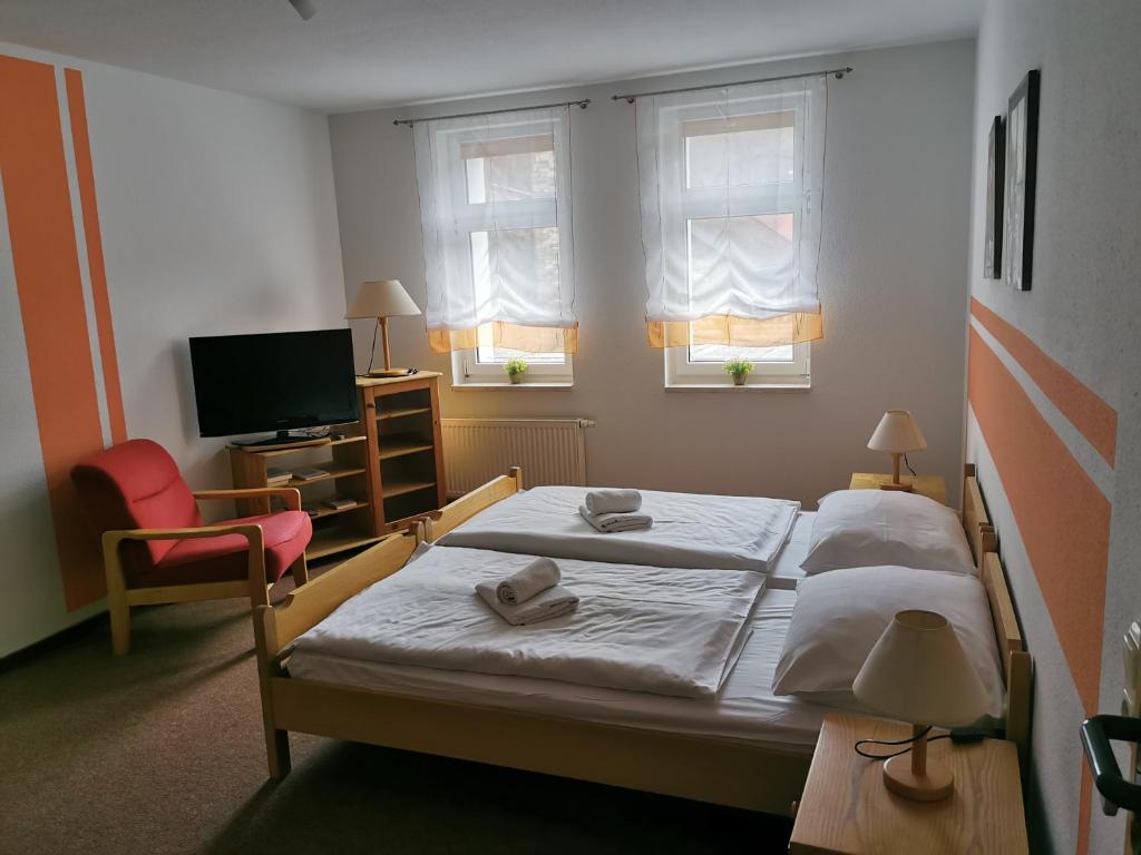 Duas camas num quarto com uma televisão e duas janelas em Harzbaude - Pension Gasthaus Bodetal em Rübeland